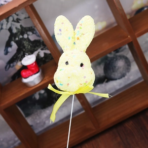 Detail of yellow Easter bunny pick with colorful sequins and a yellow ribbon bow decoration