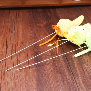 Easter foam rabbit and carrot picks with colorful ribbons on dark wood surface