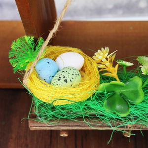 Easter bird nest decoration with colorful eggs and green artificial grass on a wood base