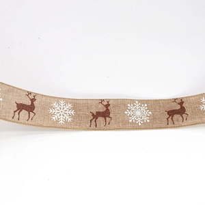 Close-up of burlap Christmas ribbon featuring brown reindeer and white snowflakes patterns