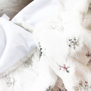 Dettaglio del tappeto per albero di Natale in ecopelliccia bianca con paillettes a fiocco
