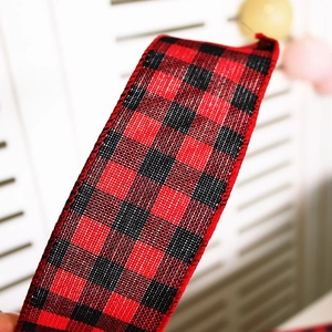 Close-up of red and black buffalo plaid ribbon with stitched edges for Christmas DIY