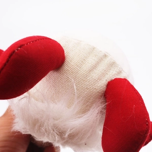 Gros plan d'un gnome de Noël en toile rouge, barbe en fourrure et texture de toile de jute