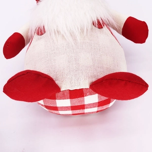 Christmas gnome doll in red and white plaid with a long white beard on white background