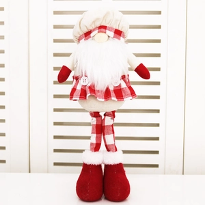 Detail view of a Christmas gnome figurine with red plaid skirt and white chef hat