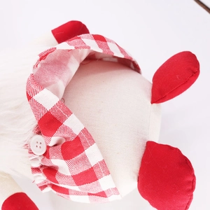 Macro detail of plush gnome showing white faux fur beard and red gingham fabric texture