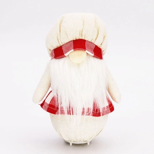 Détail d'un gnome cuisinier en peluche avec barbe blanche et chapeau à carreaux