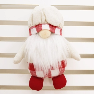 Close-up of handmade Christmas gnome ornament with red plaid hat and long white beard