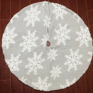 Dettaglio del tappeto per albero di Natale in peluche bianco con fiocchi 3D su legno