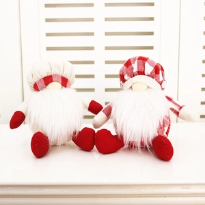 Détail de deux gnomes de Noël avec toques et détails de cœur rouge sur une clôture