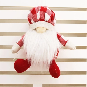 Détail d'un gnome de Noël en peluche avec bonnet à carreaux, barbe blanche et cordon