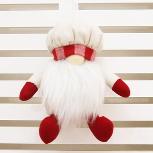 Détail d'un nain de Noël fait main avec barbe blanche et toque de cuisinier rouge