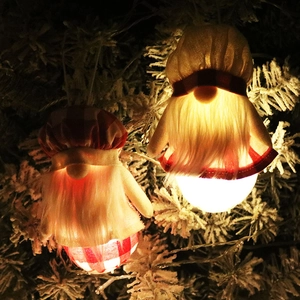Gnomes de Noël lumineux avec chapeaux à carreaux suspendus sur un sapin de Noël