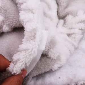 Dettaglio macro della base per albero di Natale in peluche bianco con motivi a fiocchi
