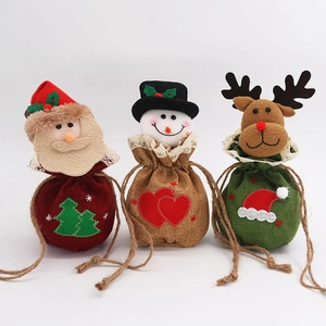 Detailed view of burlap Christmas gift bags featuring Santa, snowman, and reindeer figures