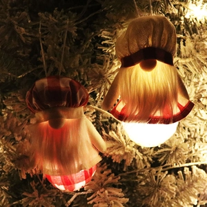 Gnomes de Noël LED lumineux suspendus à un sapin enneigé pour décor festif