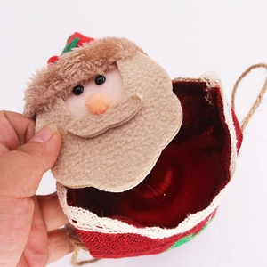 Detail showing hand opening red linen Christmas gift bag with lace trim and Santa figure