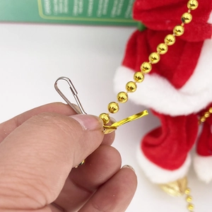 Detail of metal hook and gold bead chain connection for electric Santa Claus toy