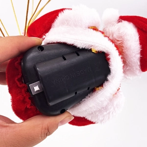 Detail of Santa Claus plush toy battery compartment and white power switch at the base