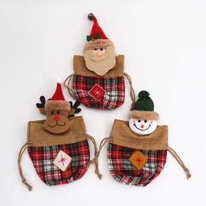 Detail of red plaid fabric Christmas gift bags with Santa, Reindeer and Snowman patterns