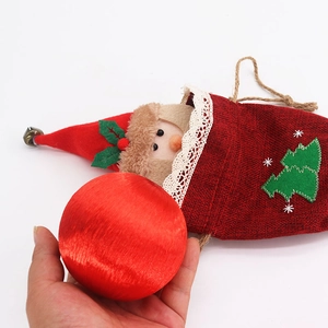 Detail of red linen Christmas gift bag featuring 3D Santa decor and white lace trim