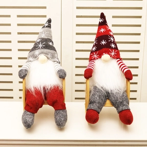 Set of two Christmas faceless gnomes with knitted hats on a small wooden bench