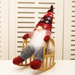 Christmas gnome doll with red knitted hat sitting on a mini rocking chair decor