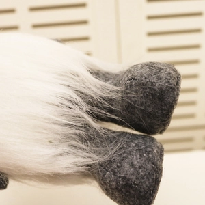 Detailed view of the soft white faux fur and grey felt fabric on a Christmas gnome doll
