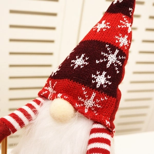 Close-up of Christmas gnome plush with knitted red snowflake hat and long white beard