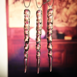 Close-up of clear acrylic twisted icicle ornaments with purple ribbon light reflection
