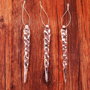 Detailed view of three clear spiral acrylic icicle ornaments for Christmas tree decoration