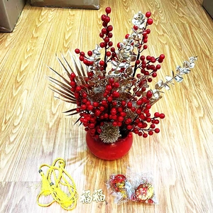 Traditional Chinese New Year red berry floral arrangement with gold leaves in festive pot