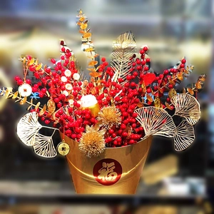 Chinese New Year lucky bucket with red berries, golden leaves, and Fortune Cat ornament