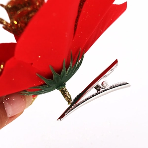 Detailed back view of red Christmas flower with gold glitter and silver metal hair clip