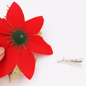 Detail view of red poinsettia Christmas flower with gold glitter and metal alligator clip