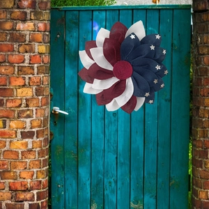 Patriotic 48cm red white and blue star wreath hanging on a rustic teal wooden door