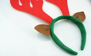 Close-up of a festive Christmas antler headband with red felt horns and green fabric base