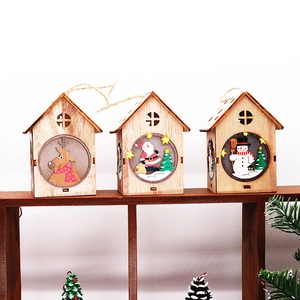 Dettaglio di tre casette di Natale in legno illuminate con motivi festivi dipinti a mano