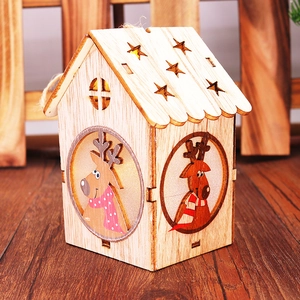 Dettaglio di casetta natalizia in legno con luce LED e illustrazione di renne