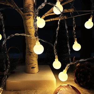 Warm white LED globe string lights on a winter tree for festive holiday decoration
