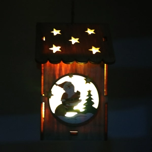 Dettaglio luminoso della casetta di Natale in legno con LED caldo e intaglio di Babbo