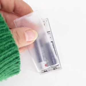 Detail of transparent battery box with AA battery slots for warm LED bulb string lights
