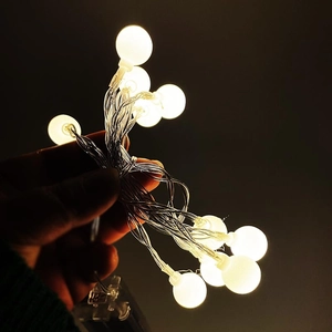 Detail of warm white LED globe string lights with transparent battery box for decoration