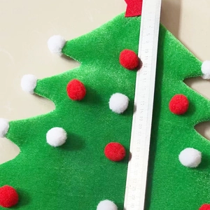 30cm Green velvet Christmas tree hat with festive red and white pompoms on yellow background