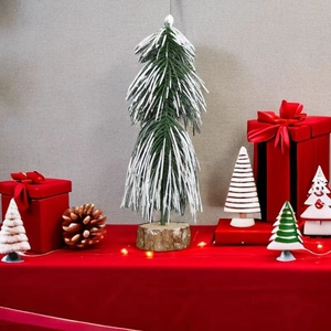 Detailed view of a 20cm frosted PE mini Christmas tree with white snow and wooden base
