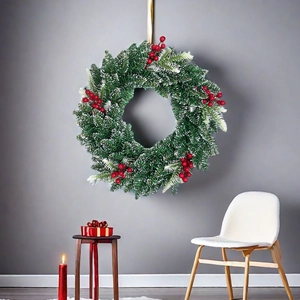 Green Christmas wreath with red berries and snow frost effect hanging in a cozy room