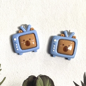 Detail of blue TV-shaped resin pendants with cute brown bear motifs for DIY jewelry