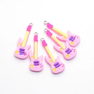 Primer plano de colgantes de guitarra eléctrica en resina rosa y amarilla con aros de metal
