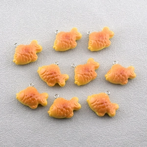 Macro detail of nine realistic resin fish cake charms with silver jump rings for DIY