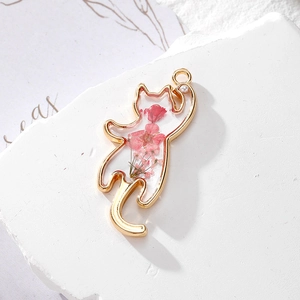 Detailed view of cat-shaped gold pendant with real pink dried flowers in resin